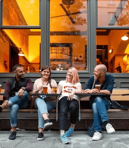 friends-enjoying-beer-at-outdoor-table-2024-10-18-06-21-23-utc